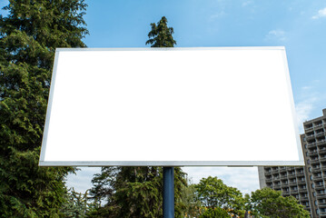 big billboard on a background of sky and trees. White background for replacement. MOCKUP.