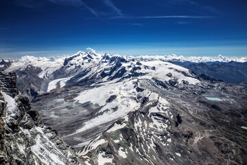 Alpine beautiful landscape. Panoramic view on Alps peaks and glacier. Beautiful blue sky.