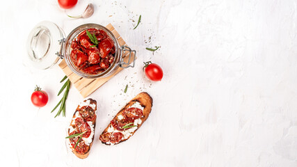 Tasty savory Italian appetizers. Bruschetta with olive oil, sundried tomatoes, cottage cheese. top view. space for text. Long banner format