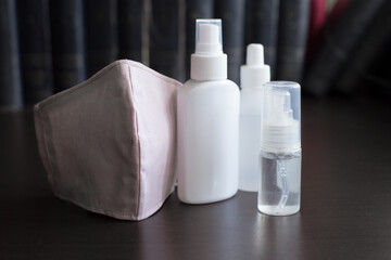 Facemasks on Dark Background with three bottles of sanitizers A respirator protects the wearer from inhaling hazardous atmospheres, including fumes, vapors, gases and particulate matter such as dusts