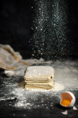 Homemade raw puff pastry on black background