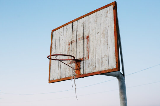 Close up weathered basketball board against the background of the sky.