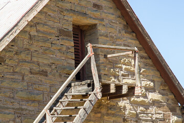 Close up of masonry work on barn on farm  with rickety steps to loft