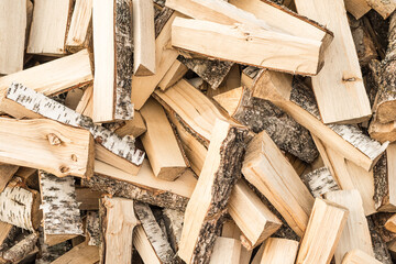 Dry split birch wood for the fireplace, stove, fire. Harvesting firewood for the winter. Texture for background.