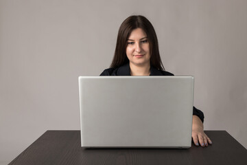 Naklejka premium Young woman in blue with laptop.