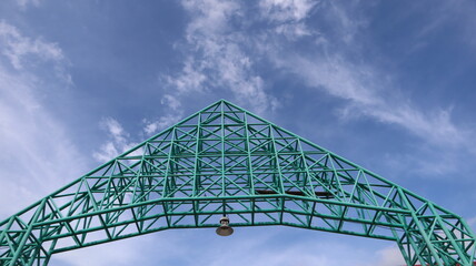 Above the entrance arch is made of steel frame and bright sky.
