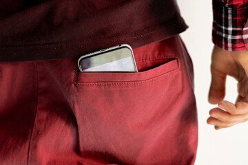 close up smartphone inside the pocket of male clothes, back view, as symbol of health effect from...