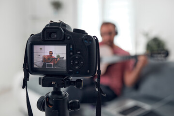 Guitarist making video lessons and tutorials for internet vlog website classes.
