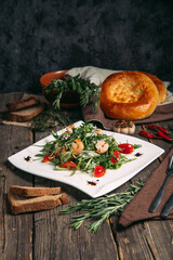 Side view on arugula shrimps and tomatoes salad