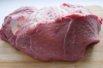 A large piece of pulp of fresh beef on a wooden surface. Ingredient, meat for cooking and butchering. Dietary meat, protein. Beef fillet on the board. Price increase, meat price increase
