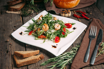 Side view on arugula shrimps and tomatoes salad