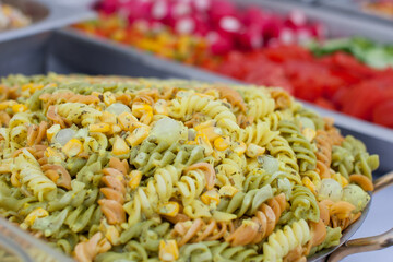 Colorful pasta salad in a buffet setup at a barbecue