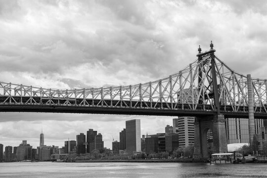 Black and White Photo of the Queensboro Bridge over the East River with the New York City Skyline on a Cloudy Day © James