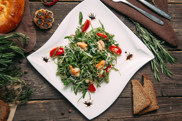 Top view on arugula shrimps and tomatoes salad