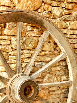 Vintage cart wheel against a stone wall