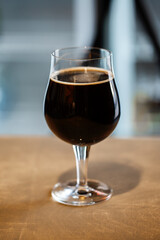 Snifter glass of russian imperial stout craft beer on wooden surface