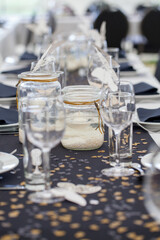 Festive dining table setting, with candles in glass jars, hearts and colors, vintage crockery and cutlery, closeup. High quality photo