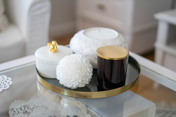Trendy home deccoration - 
candles on a golden tray staying on the table
