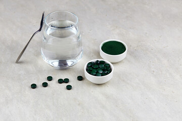Obraz na płótnie Canvas Chlorella or spirulina with water in a glass on light background. Concept of superfood and detox.