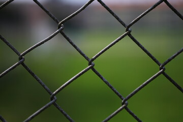 Close up of a fence against a ​green background 