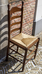 Fototapeta na wymiar old wooden chair in front of a brick wall
