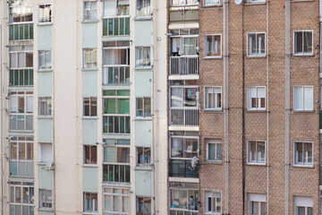 Fototapeta na wymiar Fachada y ventanas de un típico edificio de viviendas del barrio obrero burgalés de Gamonal, en la calle Vitoria. Tomada en Burgos en abril de 2020.