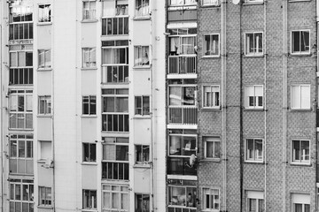 Fachada y ventanas de un típico edificio de viviendas del barrio obrero burgalés de Gamonal, en la calle Vitoria, blanco y negro. Tomada en Burgos en abril de 2020.