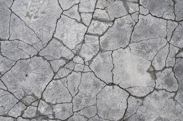 Terrain road with small rocks and cracks on the concrete wall.
