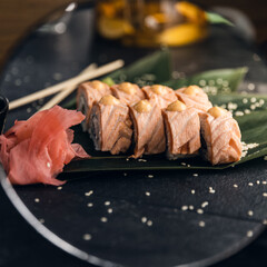 sushi rolls with rice and fish, soy sauce on a dark stone background concept of sushi restaurant summer mood 
