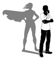 A doctor or nurse woman in silhouette wearing scrubs revealed as a super hero by her shadow.