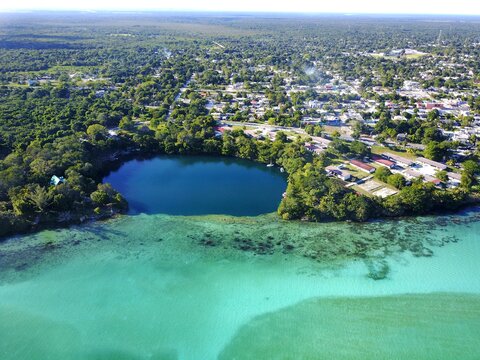 aerial view of lagoon with turquoise waters and blue water cenote