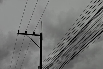 Fototapeta premium electric pole and wire on cloudy day in monochrome tone