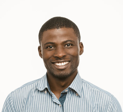 Toothy smiling African American man in shirt on white background. Portrait of positive dark-skinned guy in formal clothes. Toned image.