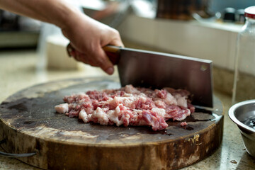 A chef is chopping minced pork