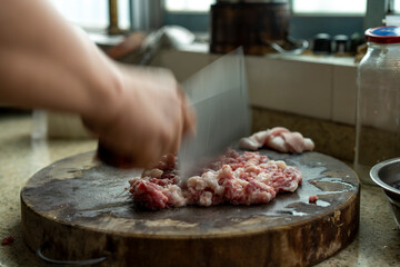 A chef is chopping minced pork