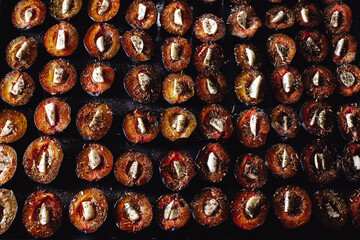 Prepare dried plums in the oven in the kitchen. Dried plums with garlic. Plums on a baking sheet. Plums and garlic in the oven.