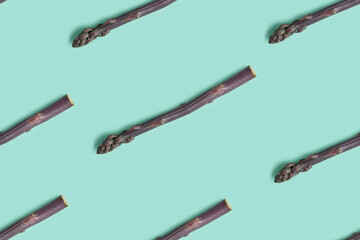 Seamless pattern from fresh natural asparagus spears on a pastel blue background. Flat lay.