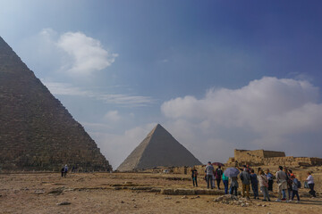 Fototapeta na wymiar Giza, Egypt: Tourists and guides exploring the Khufu pyramid complex.