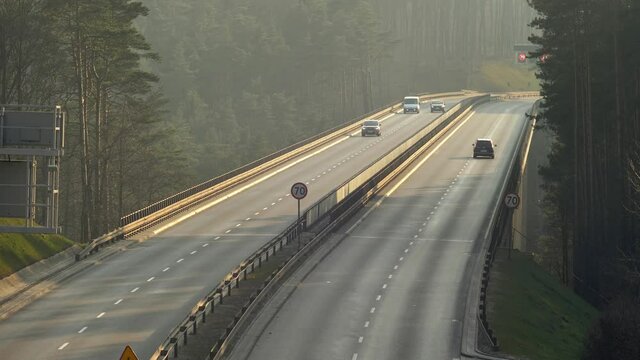 Cars Driving Highway Overpass In Forest at Sunset in Poland