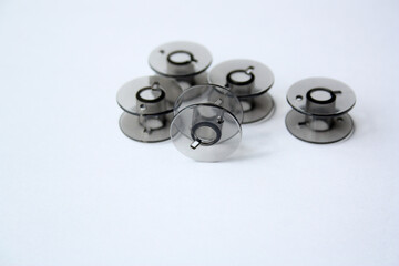 Plastic spools for thread. Black bobbins on a white background.There is free space for text.
