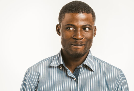 Smiling African American man looking at side. Dark-skinned young man in striped shirt isolated on white background. Toned image.