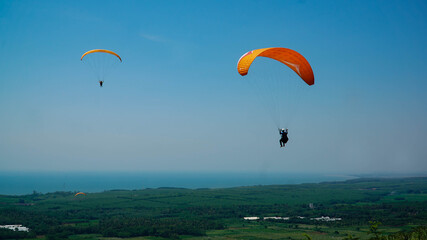 Paragliding flying in the blue sky.