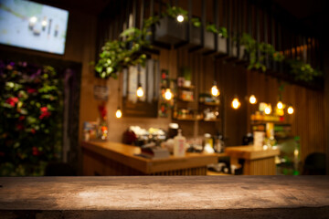 Fototapeta na wymiar Empty wooden table top on blur light golden bokeh of cafe restaurant, bar in a dark background.