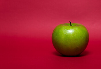 Green apple on a red background