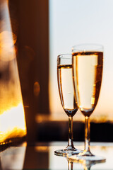 glass of champagne with splashing bubbles in the setting sun