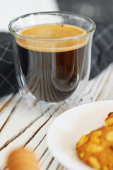 Glass cup of coffee on wooden kitchen table