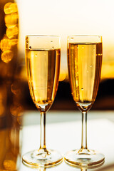 glass of champagne with splashing bubbles in the setting sun