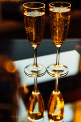 glass of champagne with splashing bubbles in the setting sun