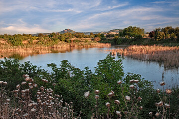 Obraz premium Forlimpopoli, Forli-Cesena, Emilia Romagna, Italy: landscape with a pond and the hill town Bertinoro on background