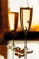 glass of champagne with splashing bubbles in the setting sun